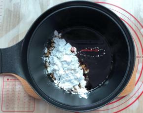 煮开后的红糖水，立刻把称好的木薯淀粉先倒入一半