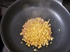然后放入玉米粒，翻炒均匀。
