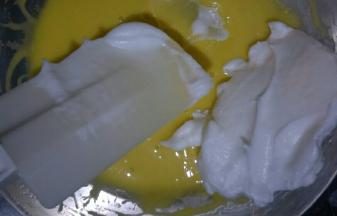 取二分之一蛋白放入蛋黄糊中，用刮刀翻拌均匀(不可画圈搅拌)