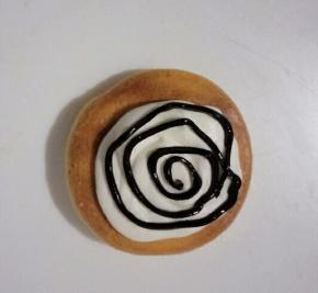 取一片蛋糕底部朝上，挤一层淡奶油，再挤一圈表情装饰的巧克力