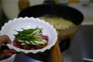 再将牛肉丝及葱段下锅炒至牛肉熟透就可以。