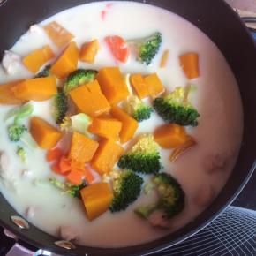 锅内倒入豆浆，中小火煮开后放入鸡肉、西兰花、萝卜花和南瓜。