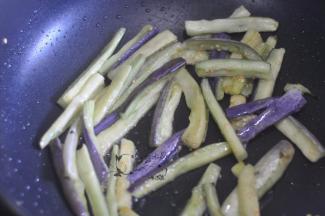 将茄子的水分挤掉，锅里倒一点点油将茄子煸软。