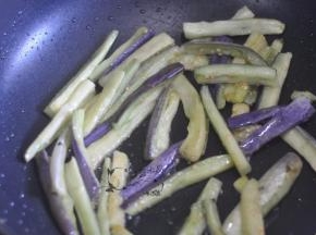 将茄子的水分挤掉，锅里倒一点点油将茄子煸软。