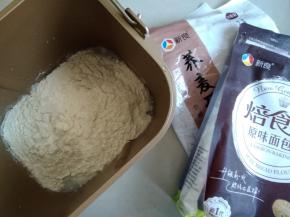 水、糖、盐、奶粉和面粉依次倒入面包桶里