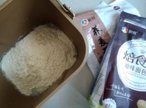 水、糖、盐、奶粉和面粉依次倒入面包桶里