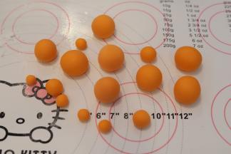 白色干佩斯加入一点橘色的食用色素，揉匀，搓成大小不一的圆球。