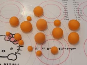 白色干佩斯加入一点橘色的食用色素，揉匀，搓成大小不一的圆球。