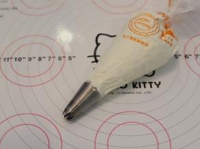 裱花袋装好8齿裱花嘴，淡奶油加入细砂糖，打发至裱花状态，装入裱花袋内。