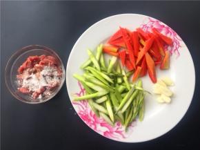 将芦笋和胡萝卜切成如图所示，大蒜切片，牛肉切条加适量淀粉拌匀。