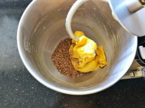 6、倒入熟亚麻籽启动一档揉2分钟，将熟亚麻籽完全均匀的揉入面团中。