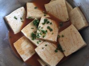 豆腐放入调料内，加入一半的香葱搅拌均匀，腌制2小时左右