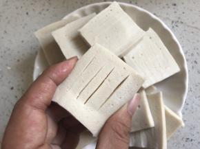 豆腐切片，中间划几道入味