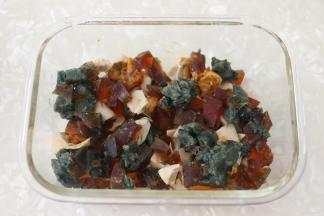 取一玻璃容器，我用的是保鲜盒，用刷子薄薄地刷一层玉米油，防止鸡蛋蒸熟后不好脱模。
先将皮蛋和咸鸭蛋铺在碗底。