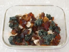 取一玻璃容器，我用的是保鲜盒，用刷子薄薄地刷一层玉米油，防止鸡蛋蒸熟后不好脱模。
先将皮蛋和咸鸭蛋铺在碗底。