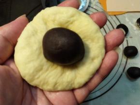 把豆沙馅直接压进松弛好的面团内。
