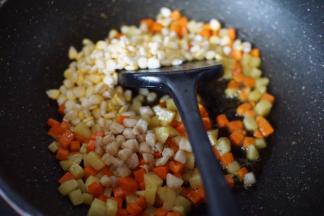 然后放入甜玉米和干贝炒出香味