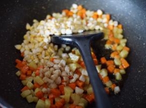 然后放入甜玉米和干贝炒出香味