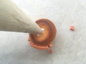 凉透的泡芙用刀在底下撮个洞，挤满淡奶油，萌粉的酥皮泡芙就可以吃啦