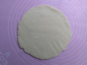 冷藏松弛好的派皮面团取出，用擀面杖擀成厚度约0.3厘米比派盘略大一圈的圆形面片
