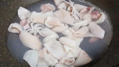 锅里加适量的清水、加生姜片3片，水开下鱿鱼入锅焯水。