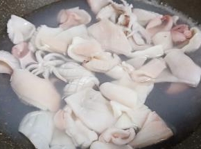 锅里加适量的清水、加生姜片3片，水开下鱿鱼入锅焯水。