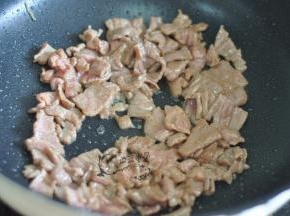 锅里倒入油，倒入牛肉片炒至变色。