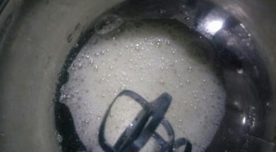 加入三分之一的糖，用手持电动打蛋器中速打发至鱼眼泡状态