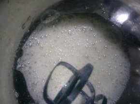 加入三分之一的糖，用手持电动打蛋器中速打发至鱼眼泡状态