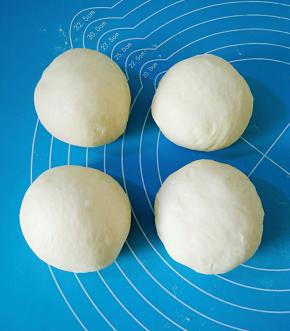 取出面团排气，分割成四份，搓圆，盖保鲜膜松弛15分。