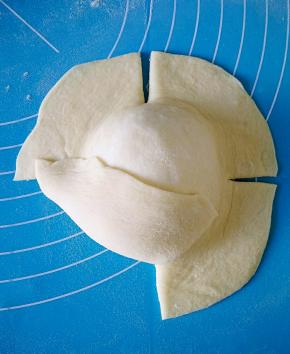 提起面团一角，往上折。