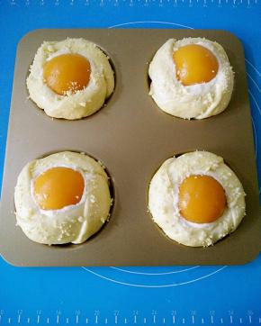 取一块黄桃放入面团中心，轻轻往下按压，表面撒适量的酥粒装饰。