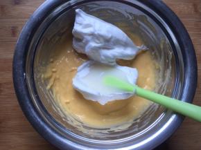 将一半蛋白倒入蛋黄糊中，用翻拌手法翻拌均匀