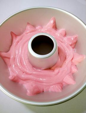 挤入屋诺空心圆模里，先挤底部一圈，再将蛋糕糊贴模具边缘挤成长短不一的三角形，轻震气泡。