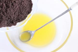 饼干放到保鲜袋中，用擀面杖压成碎末，黄油隔热水融化后，饼干碎末倒入黄油中，搅拌均匀。