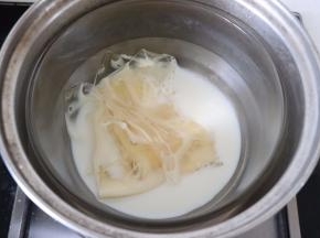 准备巧克力层的材料。吉利丁片在冷水中泡软。放入牛奶中，隔热水融化，温度不可过高，40-50度即可。