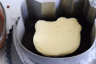 取出冰箱冷藏的模具，放入一片蛋糕片。倒入巧克力慕斯液体，放入冰箱冷藏。