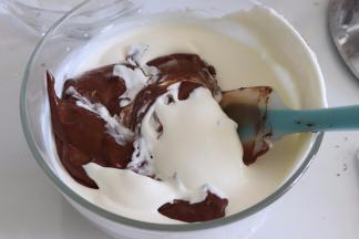 倒入一部分奶油到巧克力溶液中，翻拌均匀。再倒入剩余的淡奶油中，翻拌均匀，得到巧克力慕斯液。