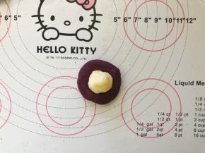 12、取一个按扁，包入一个10克的马苏里拉奶酪馅儿。