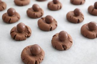 麦丽素沾一点巧克力酱，粘到饼干上。