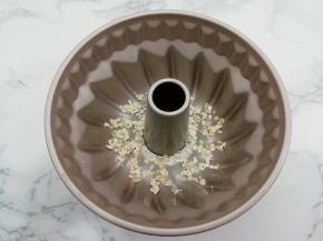 模具中刷上黄油，再把燕麦片均匀的放入底部