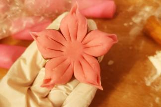 切出五等份，流出花心部分，如图，用拇指和食指捏出尖角，用戒纸刀在每瓣花划出两道线。