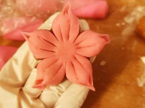 切出五等份，流出花心部分，如图，用拇指和食指捏出尖角，用戒纸刀在每瓣花划出两道线。