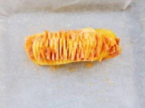 把腌制好的培根放进每片土豆的中间。烤箱230℃预热，土豆撒上预留的烤肉腌料，少许盐，白芝麻。上下火230℃烤9分钟。