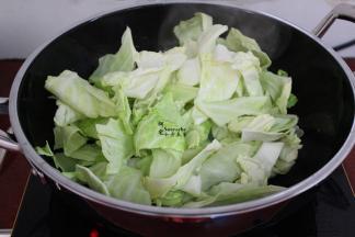 热锅，倒油，放入蒜煸香，大火倒入洗净的手撕包菜，爆炒，不断用锅铲翻炒，