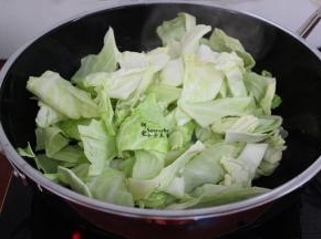 热锅，倒油，放入蒜煸香，大火倒入洗净的手撕包菜，爆炒，不断用锅铲翻炒，