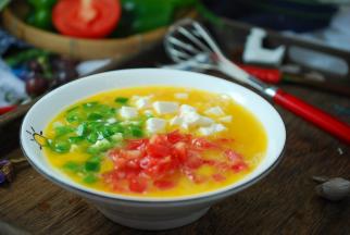 再加入切碎的西红柿丁、青椒丁、豆腐丁，混合搅拌均匀。