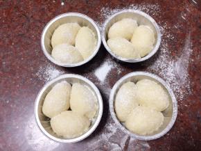 模具事先涂油撒粉，每个模具中放入2-3个搓成㮋圆形的小面团，并撒上一层糯米粉