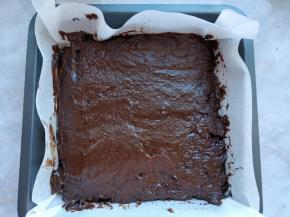 把布朗尼面糊倒入八寸方盘中，模具中垫一层烘焙纸更方便清理和脱模。