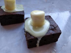 在表面挖一个小洞，把棉花糖塞入一半，将甘那许用小勺浇在上面。